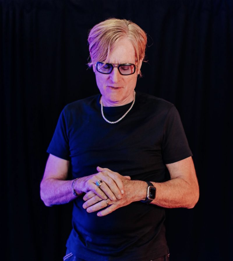 DJ Don Woodbury performing at an event with crowd in background